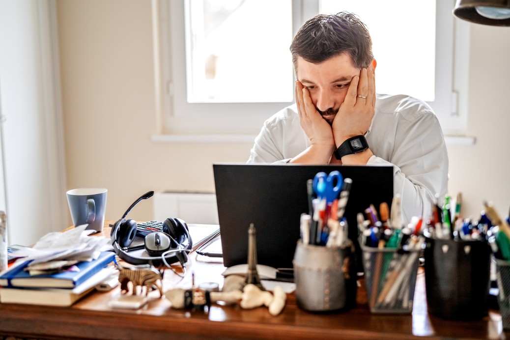 horas extras no home office - homem trabalhando em casa frustrado